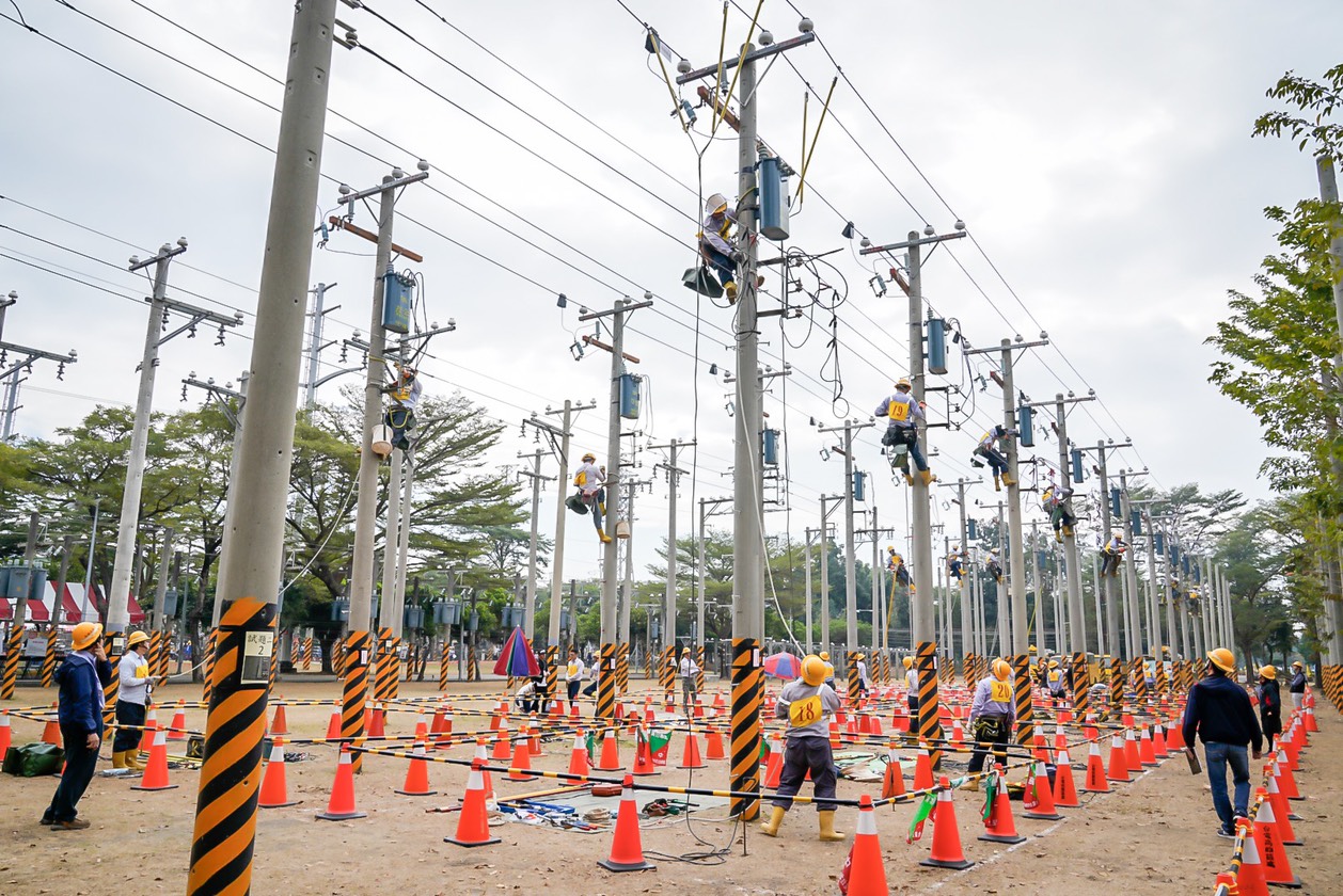 台電今舉辦技能競賽,最受關注的是模擬日常停電搶修作業的「配電外線」團體競賽,模擬「活線作業」搶修、更換故障設備,同仁全副武裝、身著逾10公斤裝備,登上近10公尺高的電線桿較勁搶修技術。