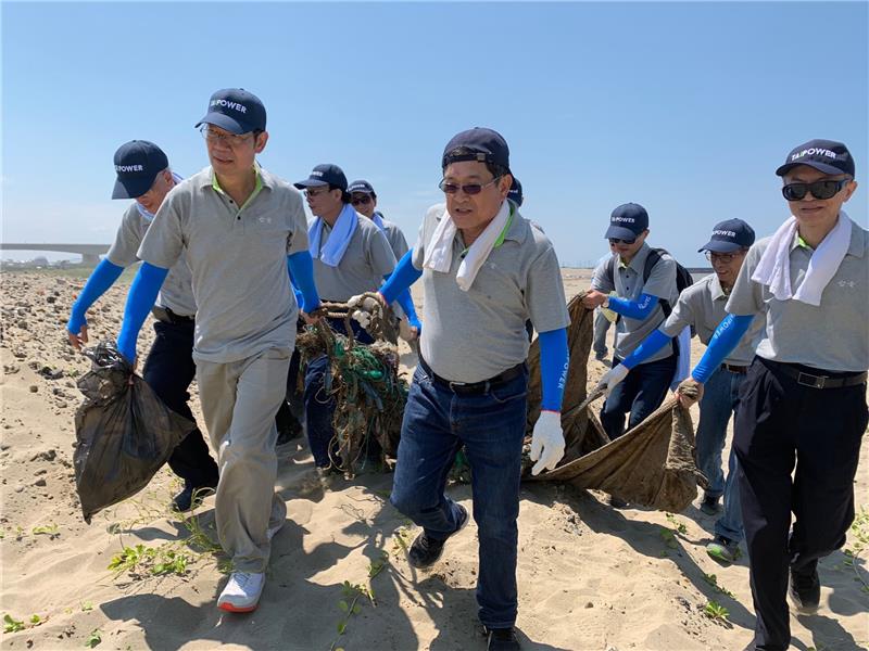 圖說:台電董事長楊偉甫(中)率主管、同仁撿拾沙灘垃圾，以實際行動守護美麗的海岸線。